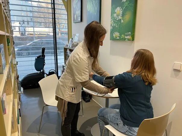 Mitarbeiterin misst einer Kundin in der Apotheke Süd den Blutdruck