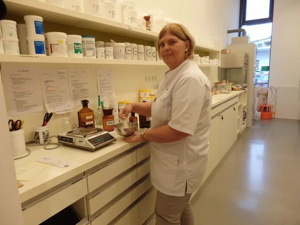 Mitarbeiterin der Apotheke Süd bei der Herstellung in der Rezeptur mit Waage und Standgefäßen