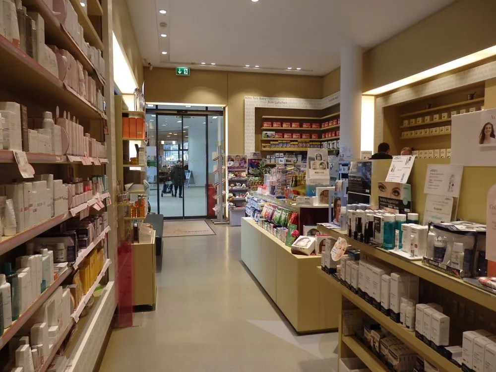 Offizin der Apotheke Süd mit Kosmetikregalen und dem Eingang im Hintergrund